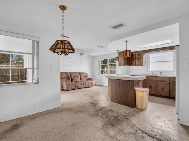 kitchen featuring pendant lighting, sink, decorative backsplash, and kitchen peninsula