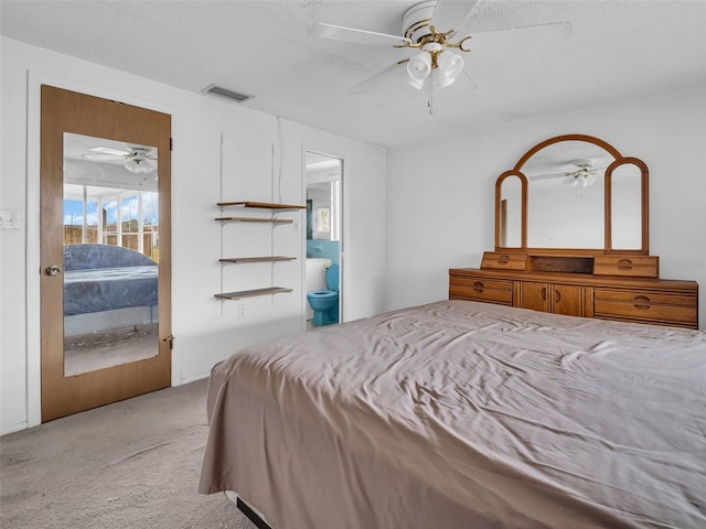 carpeted bedroom with ceiling fan, connected bathroom, and a textured ceiling