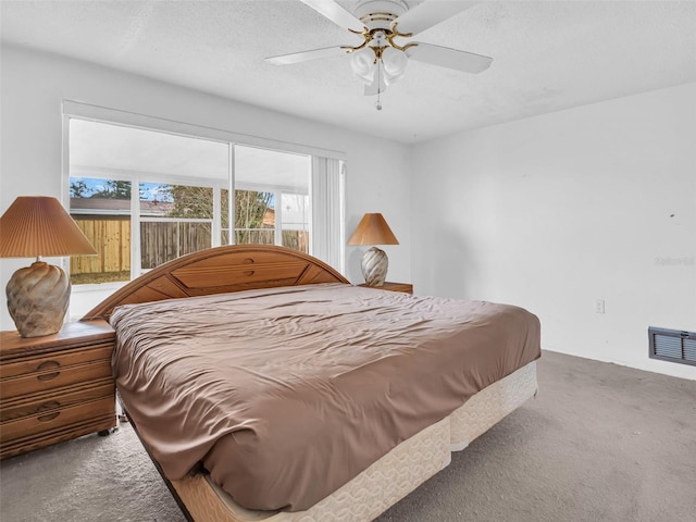 bedroom with ceiling fan, carpet, and a textured ceiling