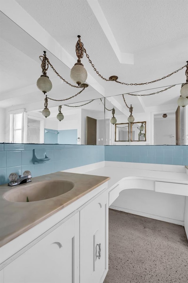 bathroom featuring tasteful backsplash, vanity, and a textured ceiling