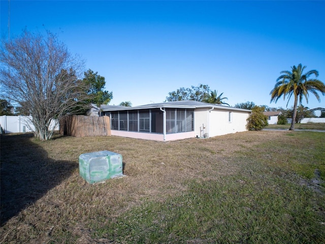 rear view of property with a yard and a sunroom