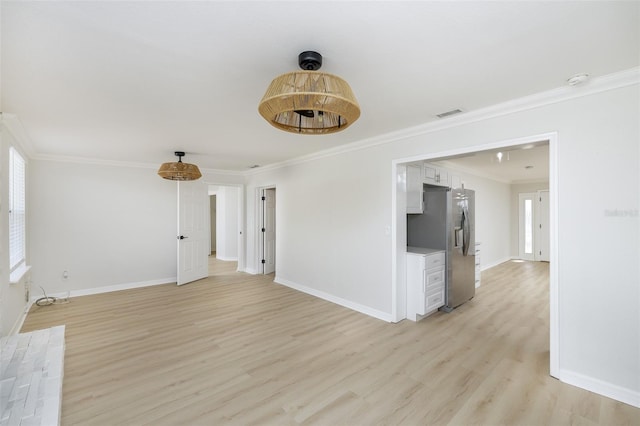 unfurnished living room featuring crown molding and light hardwood / wood-style floors