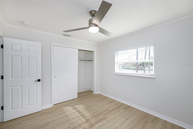 unfurnished bedroom with ceiling fan, a closet, ornamental molding, and light wood-type flooring