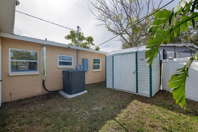 rear view of property featuring cooling unit and a storage unit