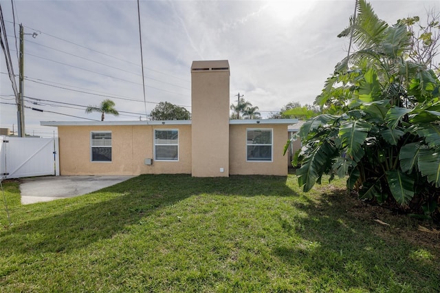 back of property featuring a patio area and a yard