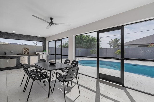 sunroom featuring ceiling fan and a pool