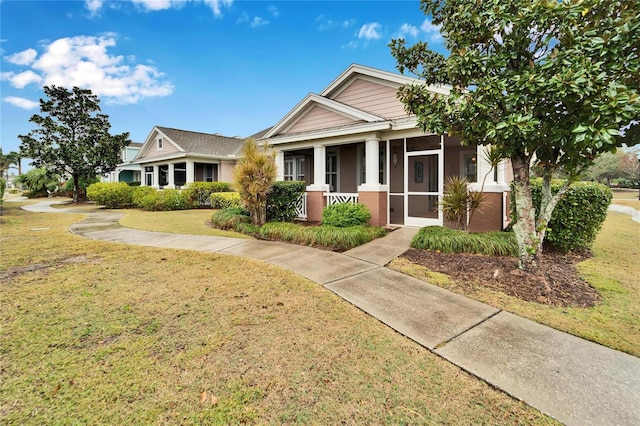 view of front of home featuring a front lawn and a sunroom