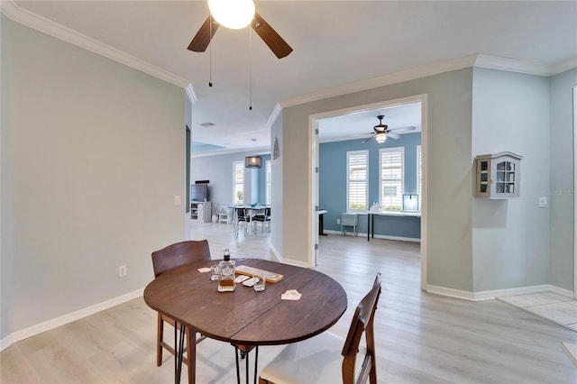 dining room featuring a healthy amount of sunlight, light hardwood / wood-style flooring, and ornamental molding