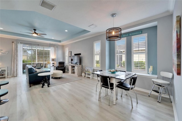 dining room featuring light hardwood / wood-style floors, ceiling fan, and a raised ceiling