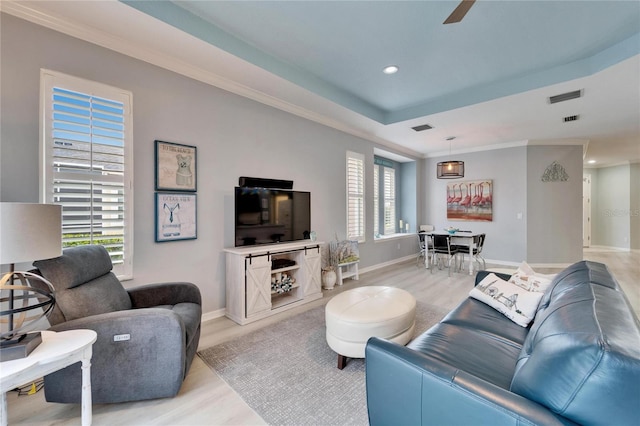 living room with crown molding, a healthy amount of sunlight, and light hardwood / wood-style floors