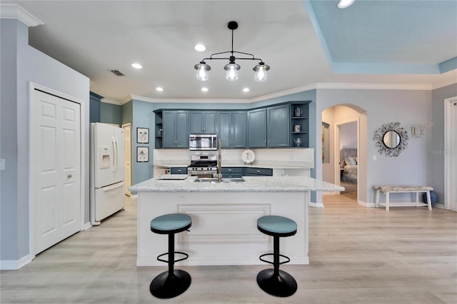 kitchen featuring light stone counters, decorative backsplash, hanging light fixtures, and appliances with stainless steel finishes