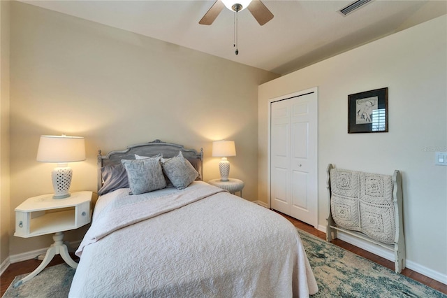 bedroom featuring dark wood-type flooring, a closet, and ceiling fan