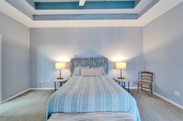 bedroom with carpet and a raised ceiling