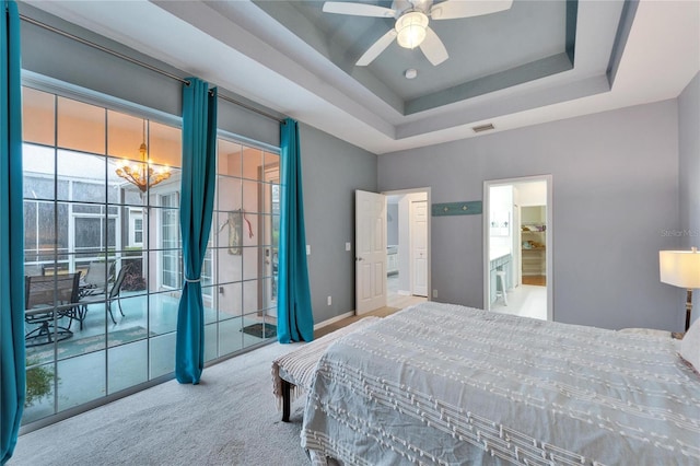 carpeted bedroom featuring ceiling fan, connected bathroom, and a tray ceiling