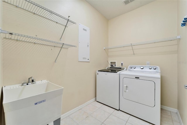 laundry area featuring sink, separate washer and dryer, and light tile patterned flooring