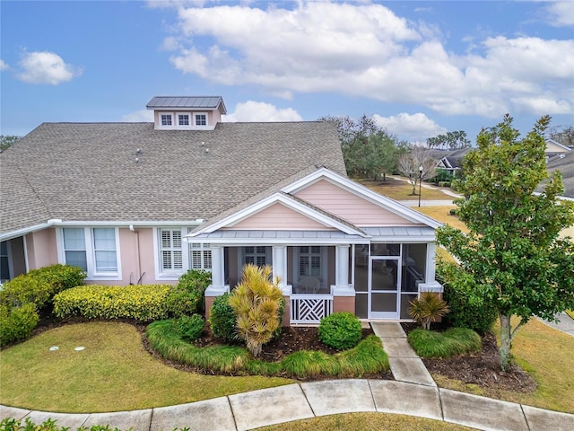 view of front of property featuring a sunroom and a front yard