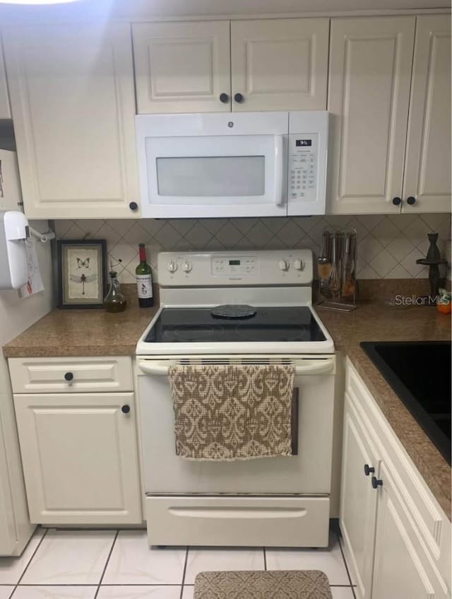 kitchen featuring white cabinetry, white appliances, light tile patterned floors, and tasteful backsplash