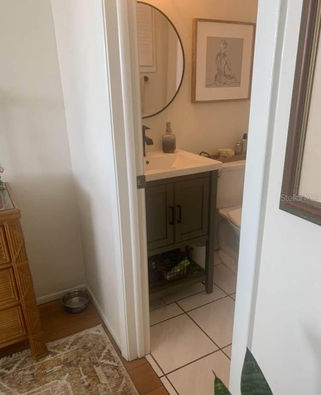 bathroom with toilet, tile patterned floors, and vanity