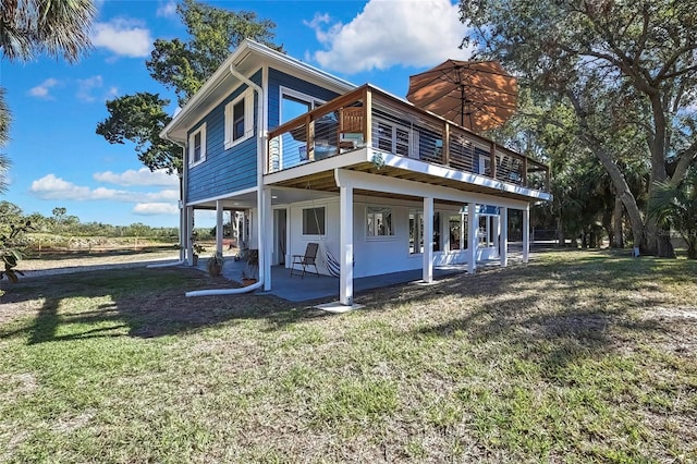 rear view of property featuring a lawn and a patio