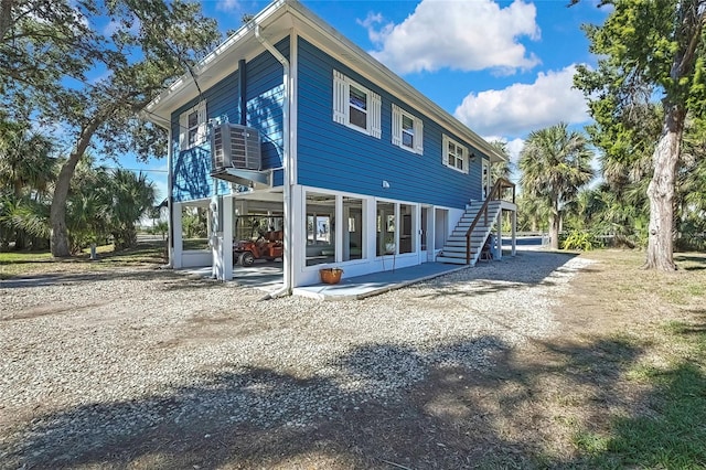 view of property exterior featuring a sunroom and central AC unit