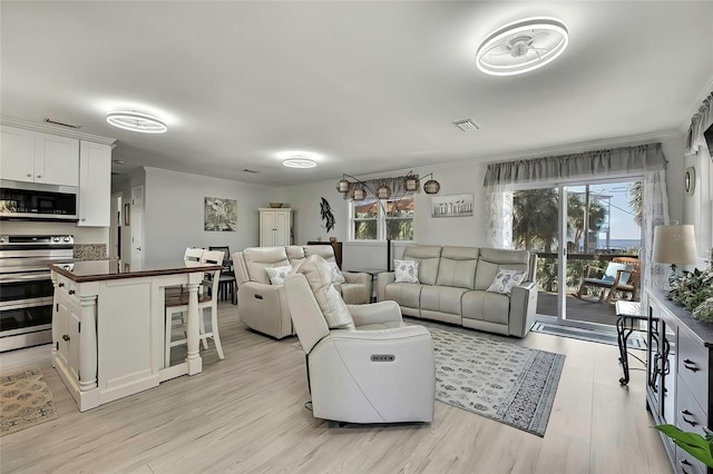 living room with light hardwood / wood-style flooring and crown molding