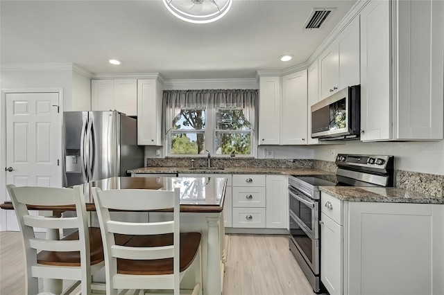 kitchen featuring sink, light hardwood / wood-style floors, white cabinetry, and appliances with stainless steel finishes