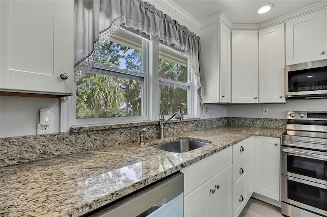 kitchen featuring light stone countertops, sink, white cabinets, and appliances with stainless steel finishes