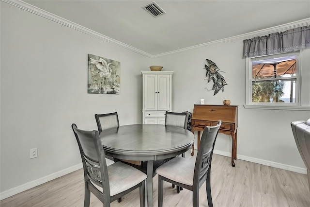 dining space featuring crown molding and light hardwood / wood-style flooring