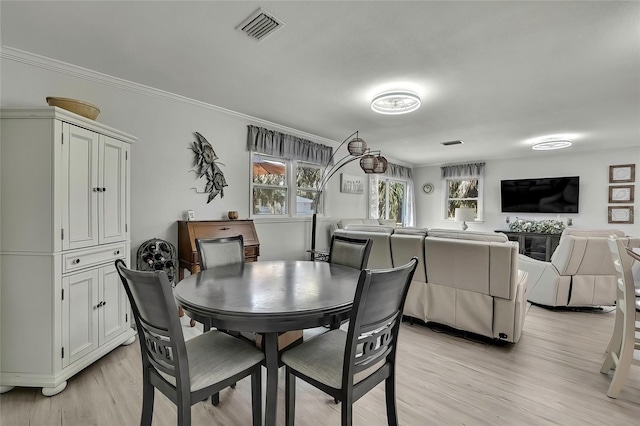 dining area featuring light hardwood / wood-style flooring and crown molding