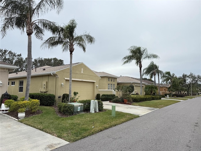 view of front of property with a garage, concrete driveway, a front yard, and stucco siding