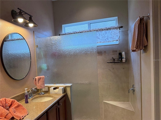 bathroom with vanity and tiled shower