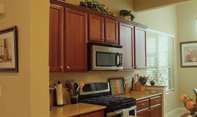 kitchen featuring stainless steel appliances, backsplash, and light countertops