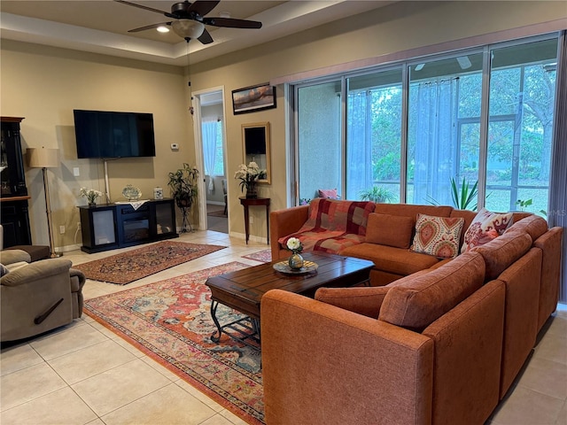 living area featuring a wealth of natural light, ceiling fan, and light tile patterned floors