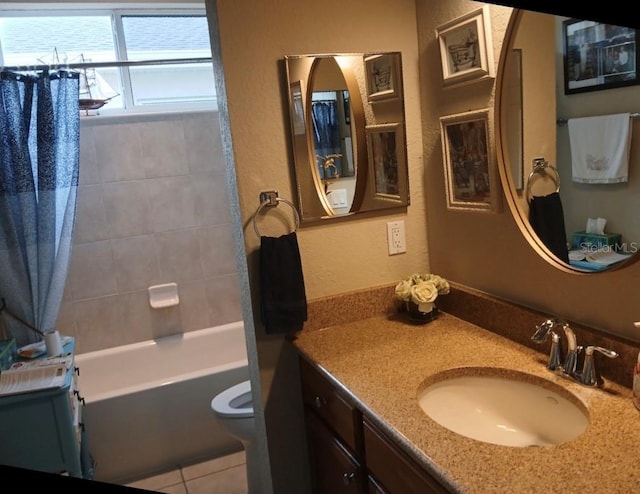 full bathroom with a textured wall, toilet, tile patterned flooring, shower / bath combo with shower curtain, and vanity