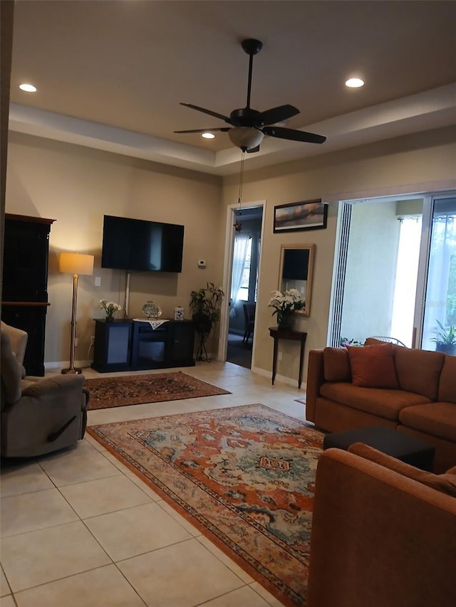 living area featuring a tray ceiling, recessed lighting, and light tile patterned floors