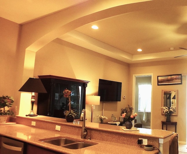 kitchen featuring dishwasher, arched walkways, a sink, and recessed lighting