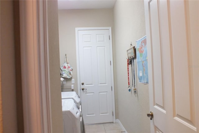 laundry area with light tile patterned floors, laundry area, washing machine and dryer, and baseboards