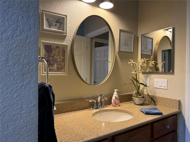 bathroom featuring vanity and a textured wall