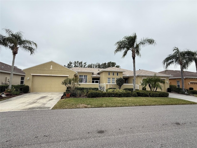 view of front of house featuring a front yard, driveway, an attached garage, and stucco siding