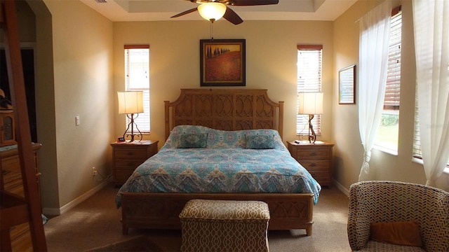 bedroom featuring light colored carpet, baseboards, and multiple windows