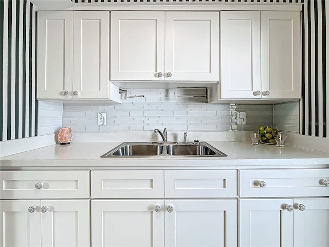 kitchen featuring sink, white cabinets, and decorative backsplash