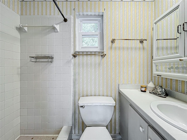 bathroom featuring vanity, toilet, and tiled shower