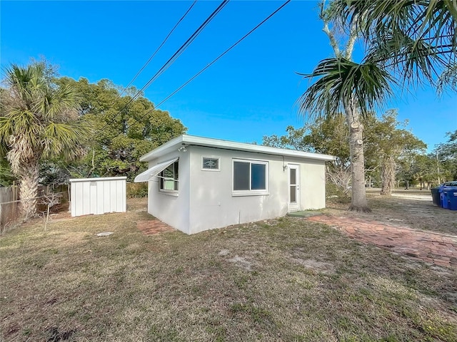 back of property with a shed and a lawn