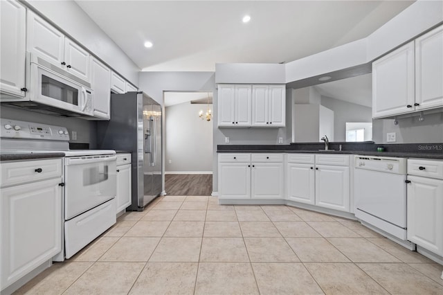 kitchen with white cabinetry, white appliances, a notable chandelier, and vaulted ceiling