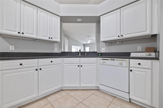 kitchen featuring light tile patterned floors, white cabinetry, lofted ceiling, dishwasher, and sink