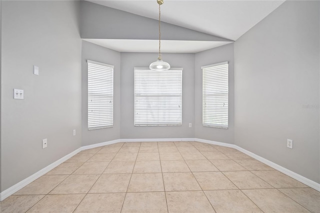 tiled spare room featuring lofted ceiling and a healthy amount of sunlight