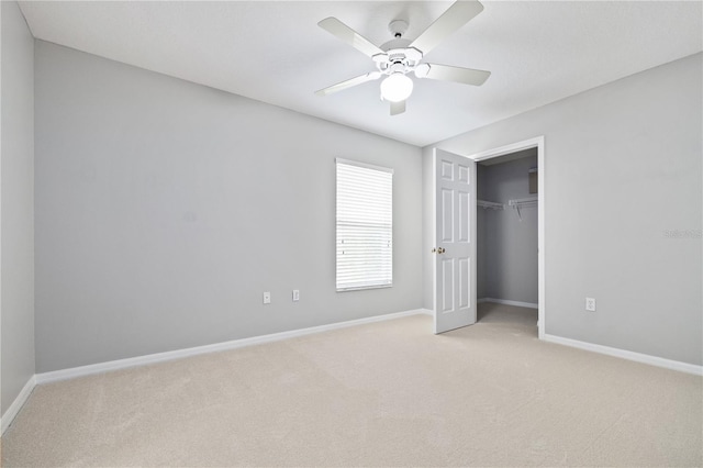 unfurnished bedroom featuring ceiling fan, light colored carpet, and a closet