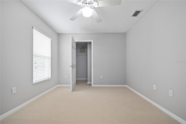 unfurnished bedroom featuring light carpet, ceiling fan, a closet, and multiple windows