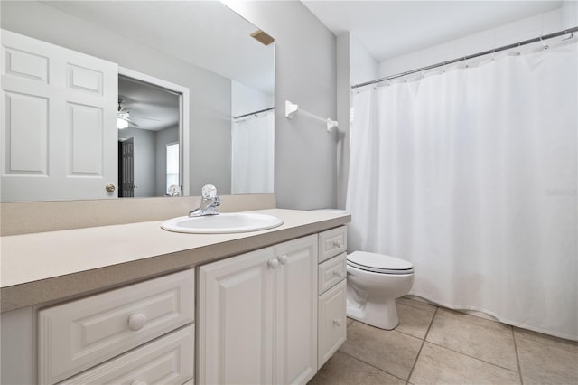 bathroom with toilet, vanity, and tile patterned flooring