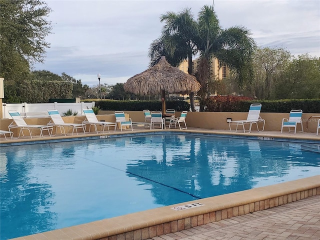 pool with a patio area and fence